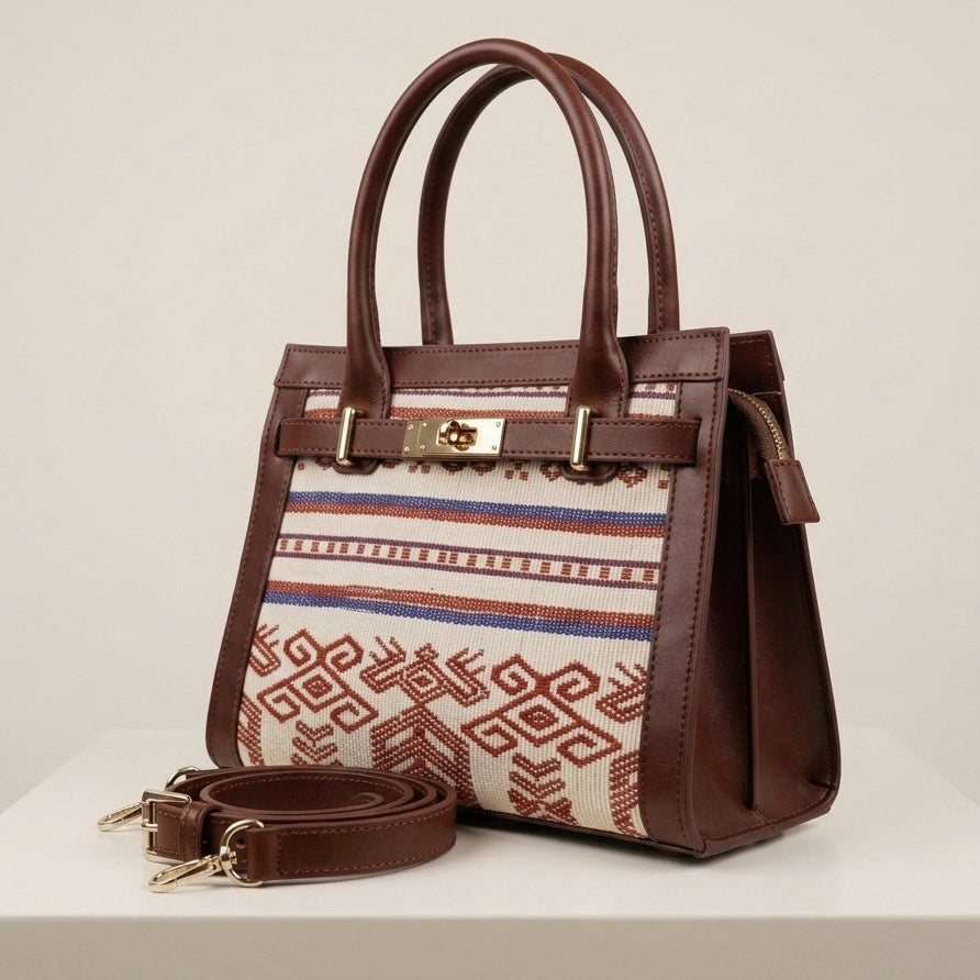 Brown handbag with patterned strap on a white surface