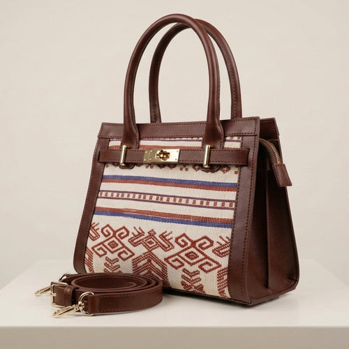 Brown handbag with patterned strap on a white surface
