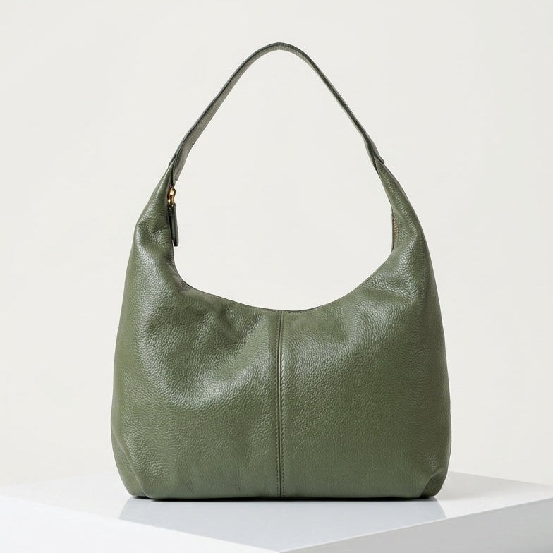Green handbag on a white platform with a light gray background