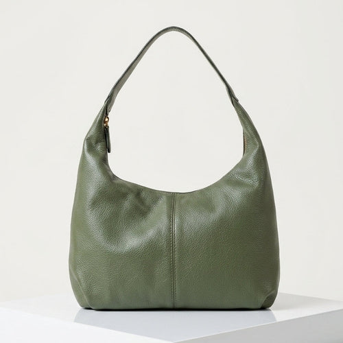 Green handbag on a white platform with a light gray background